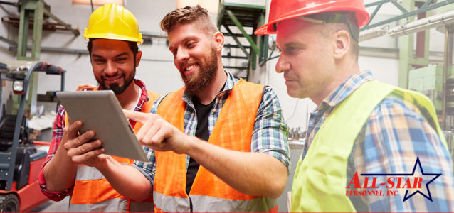3 male manufacturing workers looking at a tablet